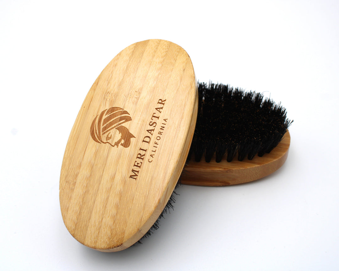 Wooden beard brush with black bristles on a white background