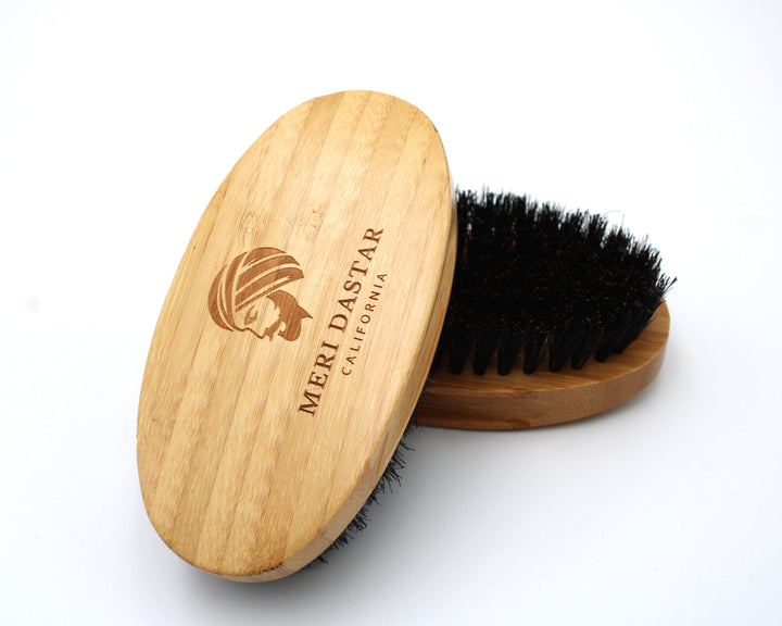 Wooden beard brush with black bristles on a white background