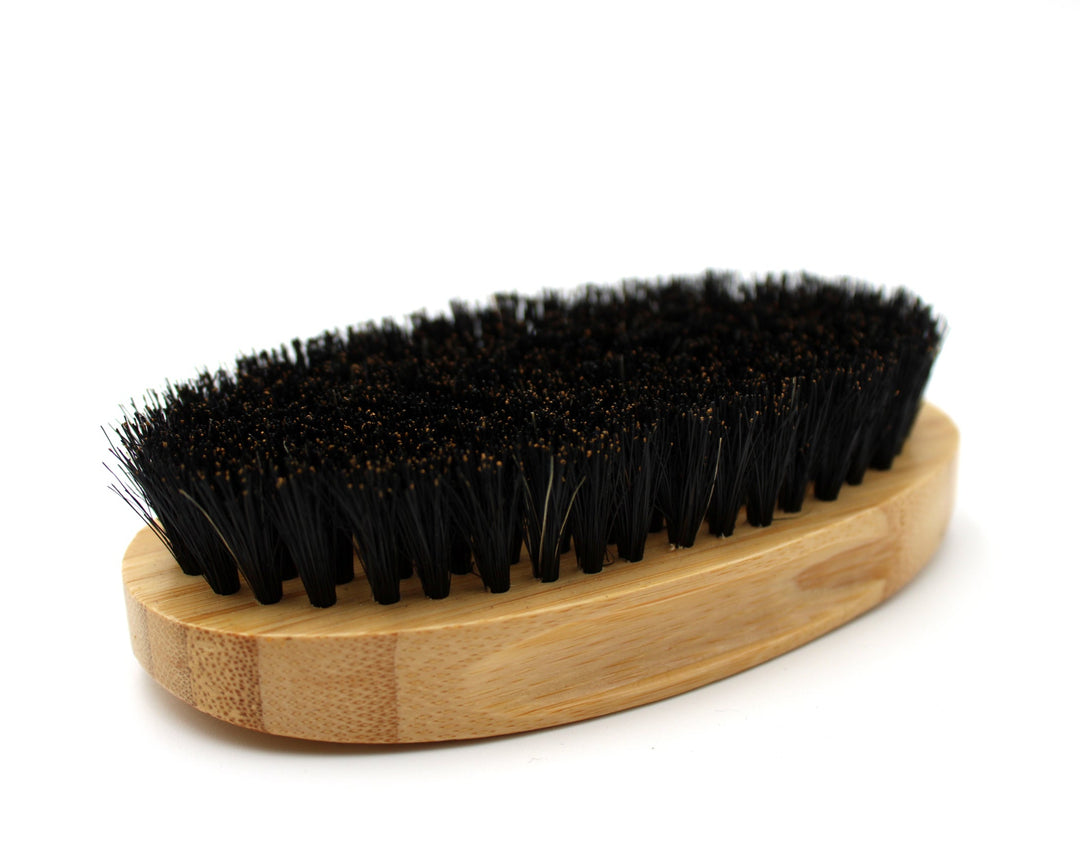 Wooden brush with black bristles on a white background