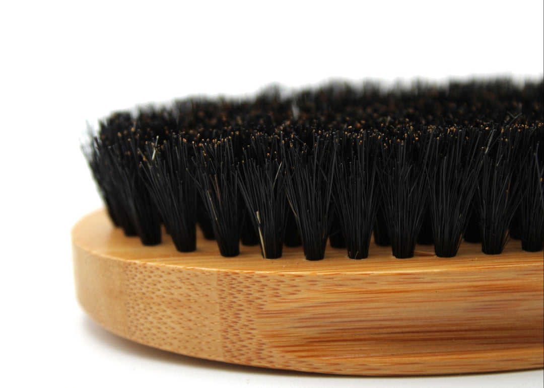 Bristle brush with wooden handle on a white background
