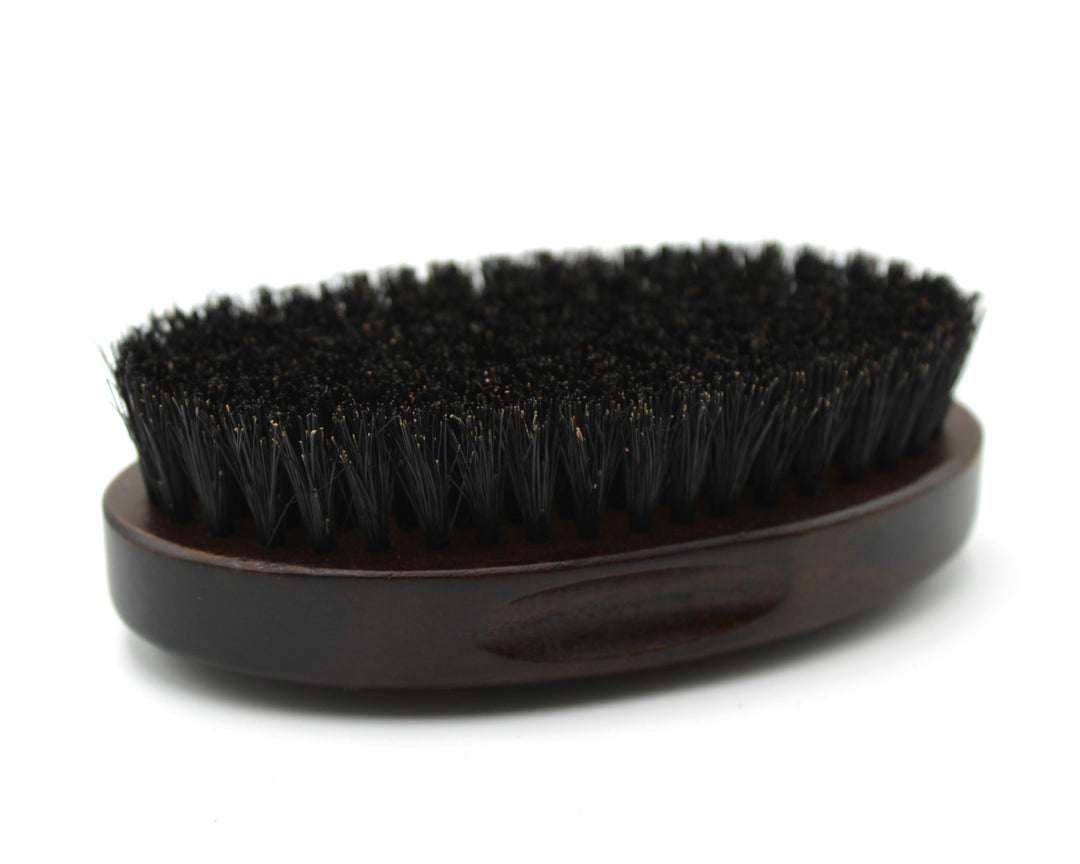 Black bristle brush on a wooden handle against a white background