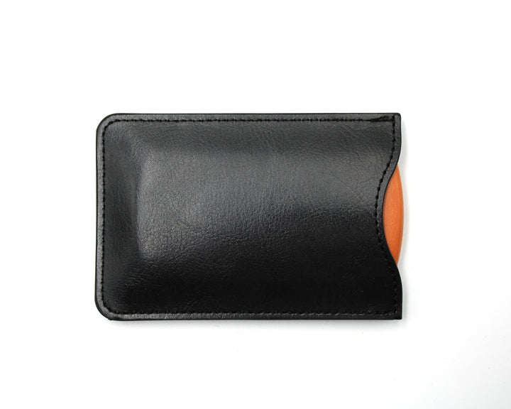 Black leather pouch with an orange comb on a white background